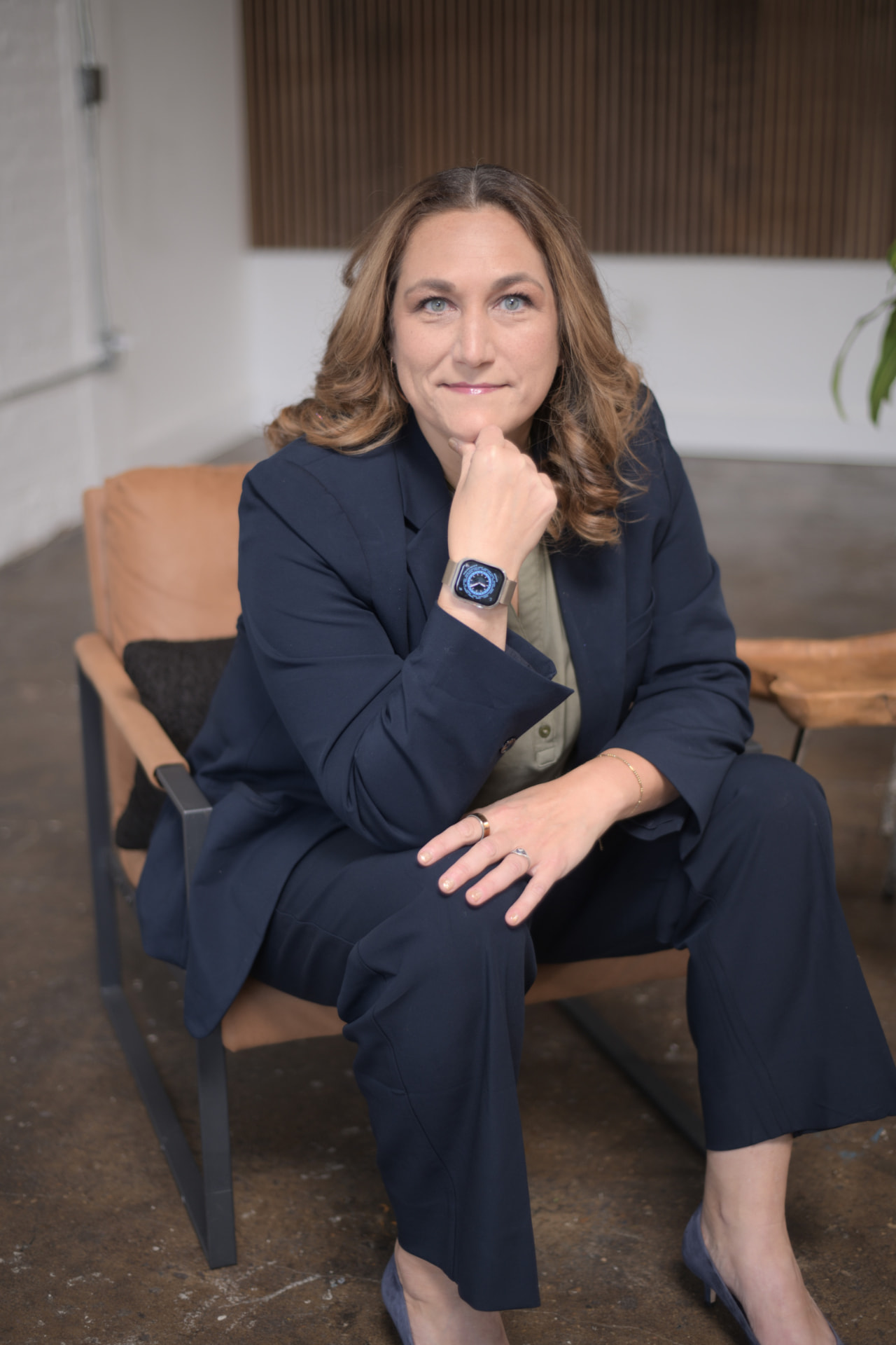 Joy St. John seated in a lounge chair, hand at her chin